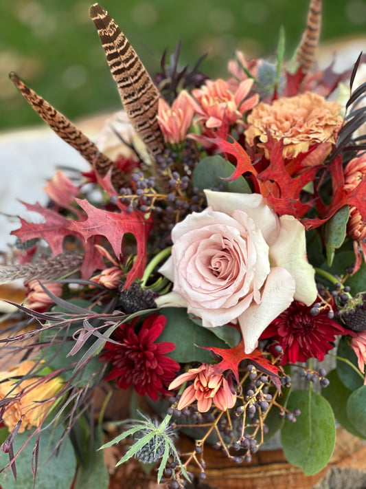 Bouquet of flowers with feathers and leaves on a blurred background